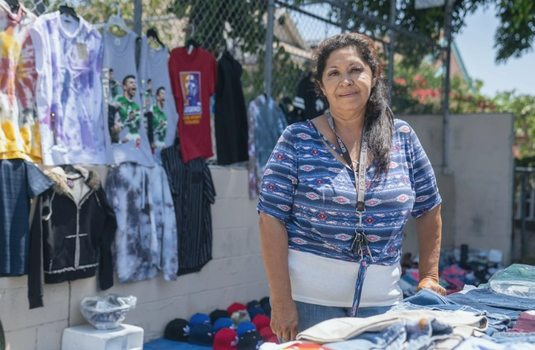Woman in front of display of t-shirts for sale
