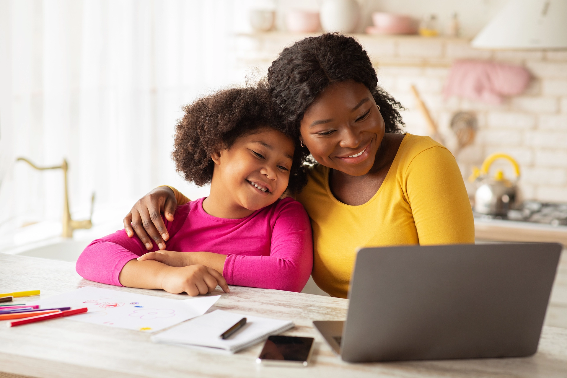 Happy African American Mother and Daughter with Laptop